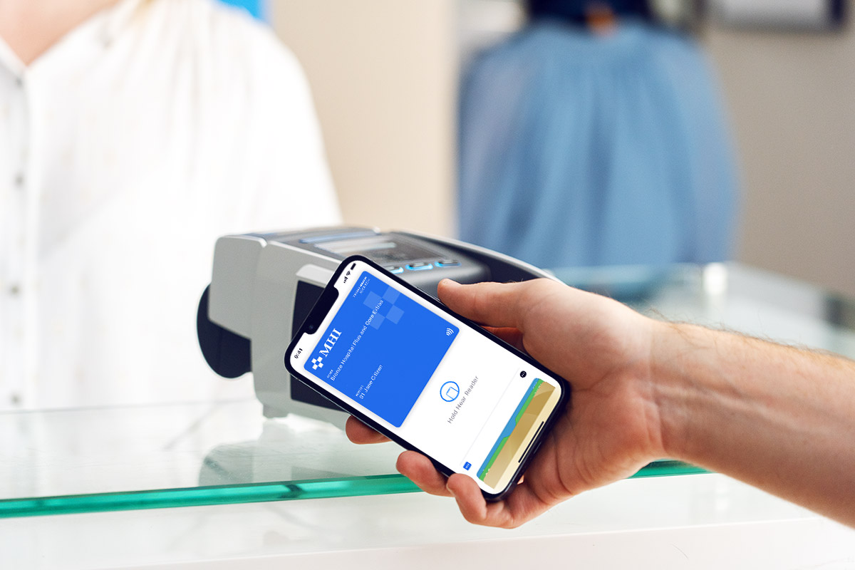 Person holding iPhone near EFTPOS machine to claim with digital health insurance card.