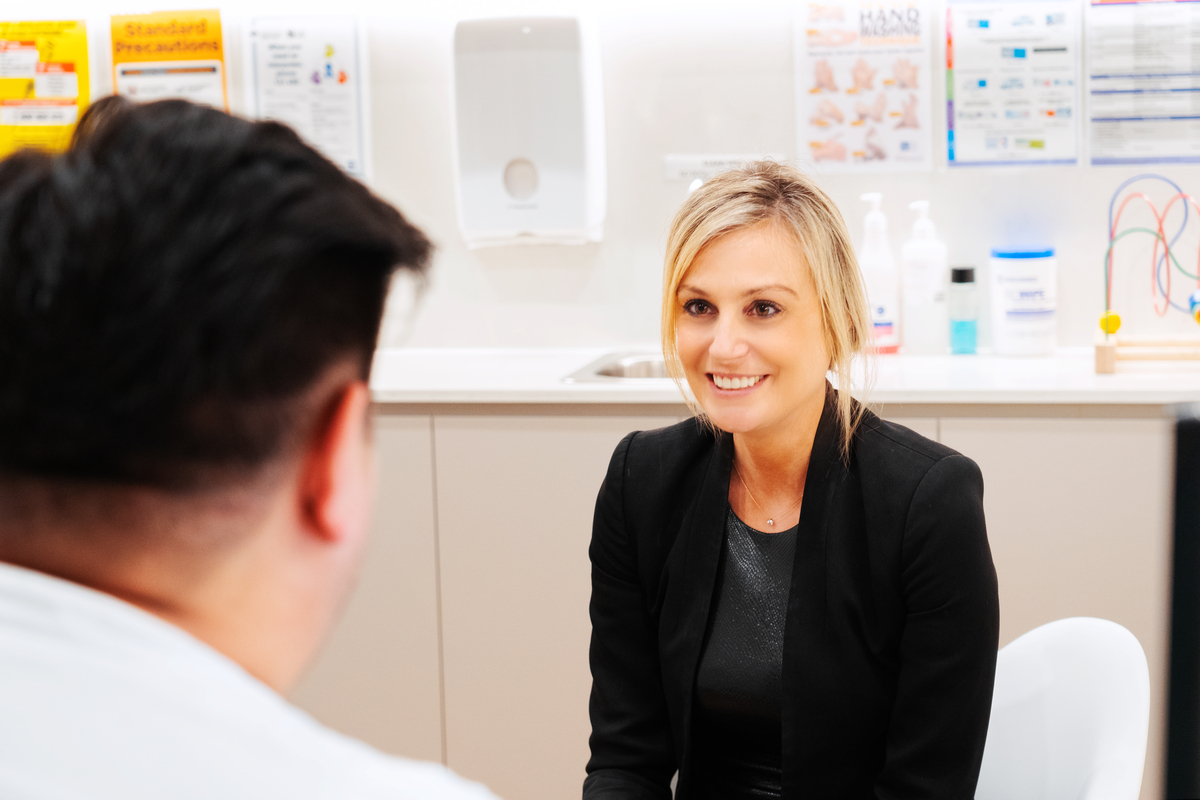 A patient engaged in a conversation with a doctor in an office setting, seeking professional medical consultation.