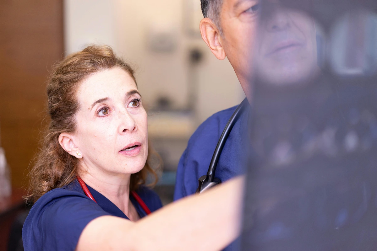 Female specialist doctor examining diagnostic scan alongside a colleague in a clinical setting