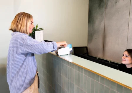 Patient tapping card to make a payment at a medical clinic reception using Tyro Health EFTPOS