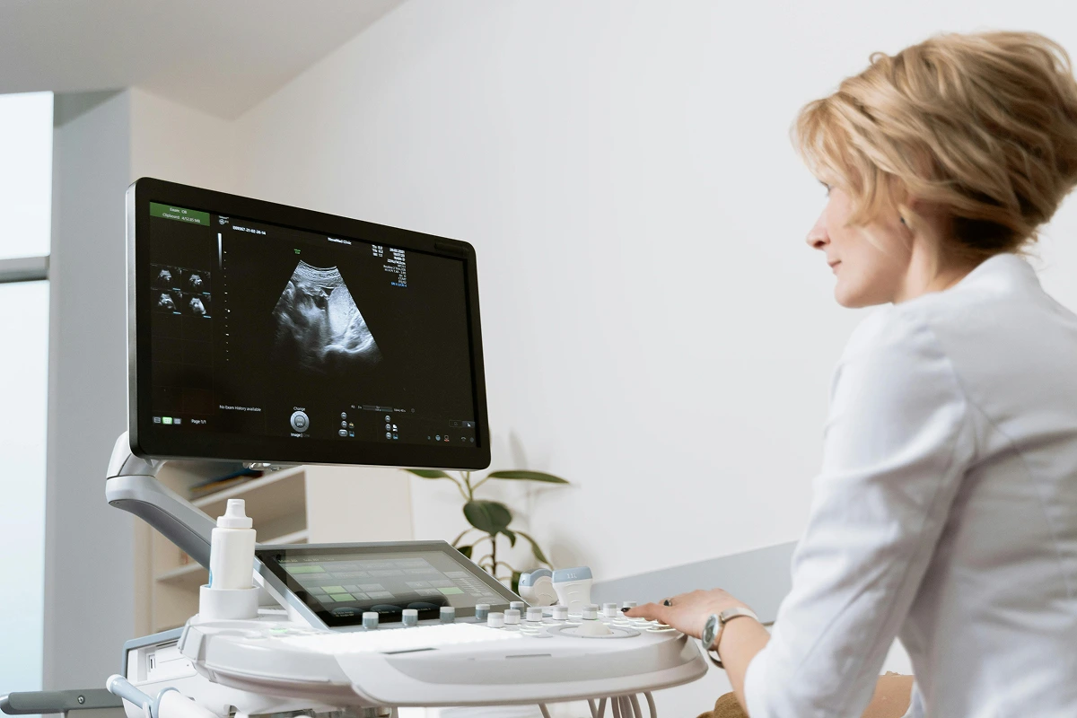 Female medical imaging professional conducting an ultrasound scan in a diagnostic clinic.