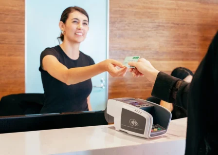 Healthcare receptionist assisting patient with secure EFTPOS card payment at front desk in Australia - Tyro Health