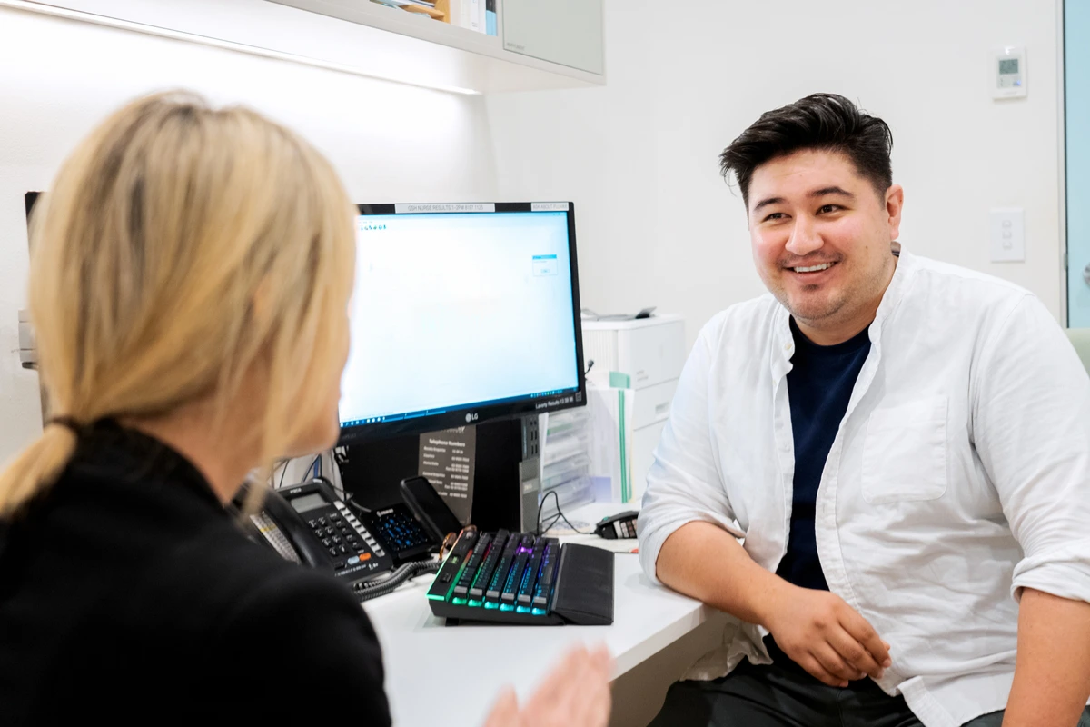 A healthcare professional talking with a patient in a medical clinic office, highlighting trust and support during a consultation.